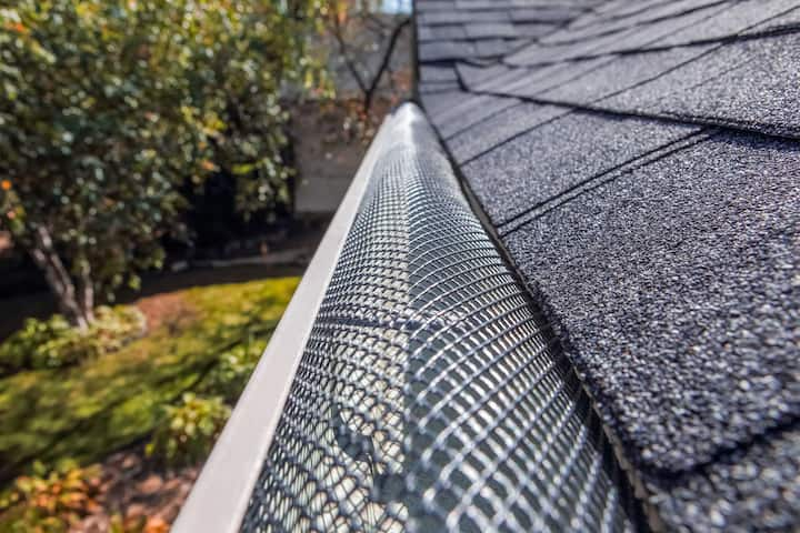 A contractor demonstrating the effectiveness of a gutter guard to a potential client in Virginia Beach